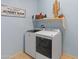 Functional laundry room with modern washer and dryer and playful decor at 26032 W Quail Ave, Buckeye, AZ 85396