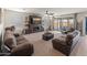 Cozy living room features a modern fireplace, ceiling fan, and view to the outdoor space at 26032 W Quail Ave, Buckeye, AZ 85396