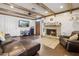 Cozy living room with a stone fireplace and beamed ceiling, alongside a plush leather sectional at 2731 N 23Rd Ave, Phoenix, AZ 85009