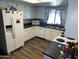 Bright kitchen featuring white appliances, light wood flooring and dark countertops at 2840 W Marlette Ave, Phoenix, AZ 85017
