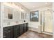 Bright bathroom with a double sink vanity, soaking tub, glass shower, and natural light at 3190 S Holguin Way, Chandler, AZ 85248