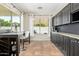 Bright kitchen featuring dark cabinets, tiled floor, granite countertops, and natural light from two windows at 3190 S Holguin Way, Chandler, AZ 85248