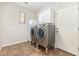 Modern laundry room with stainless steel washer and dryer, overhead cabinets, and tile flooring at 3190 S Holguin Way, Chandler, AZ 85248