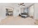 Open-concept living room with stairs, carpet flooring, gray sofa, and access to the main bedroom at 3190 S Holguin Way, Chandler, AZ 85248