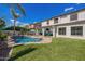 Resort-style backyard with a freeform pool, covered patio, and artificial turf, perfect for entertaining at 3190 S Holguin Way, Chandler, AZ 85248