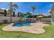 Beautiful pool area featuring palm trees, artificial turf, and an umbrella, creating a backyard oasis at 3190 S Holguin Way, Chandler, AZ 85248