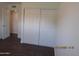 Bedroom with sliding closet doors, base trim and dark wood flooring at 327 E La Jolla Dr, Tempe, AZ 85282