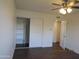 A bedroom with a ceiling fan, closet with sliding doors, and two entry doors at 327 E La Jolla Dr, Tempe, AZ 85282