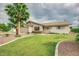 Well-manicured front yard with a large palm tree, lush green grass, and a classic single-story home at 327 E La Jolla Dr, Tempe, AZ 85282
