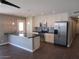 Modern kitchen with stainless steel appliances, white cabinets, and a kitchen island with black countertops at 327 E La Jolla Dr, Tempe, AZ 85282