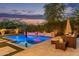 Relaxing backyard oasis with a sparkling pool, cozy lounge area, and lush landscaping at 3400 S Whetstone Pl, Chandler, AZ 85286
