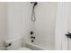 Clean bathroom featuring a shower-tub combo, white tile, and minimalist design at 3400 S Whetstone Pl, Chandler, AZ 85286
