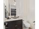 Elegant powder room featuring a unique glass bowl sink, modern faucet, and stylish black vanity at 3400 S Whetstone Pl, Chandler, AZ 85286