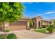 Charming exterior with stone accents, a paver driveway and lush landscaping at 3400 S Whetstone Pl, Chandler, AZ 85286
