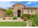 Inviting front entrance with stone archway, well-manicured lawn and desert landscaping at 3400 S Whetstone Pl, Chandler, AZ 85286