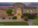 Single-Gathering home showcasing a stone archway entry and well-manicured landscaping at dusk at 3400 S Whetstone Pl, Chandler, AZ 85286