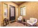 Inviting front porch featuring an ornate front door, furniture, and textured walls at 3400 S Whetstone Pl, Chandler, AZ 85286