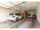 Spacious garage with epoxy flooring, ample storage cabinets, and a parked white car at 3400 S Whetstone Pl, Chandler, AZ 85286