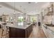 Open-concept kitchen island with seating, sink, and view of backyard and dining room at 3400 S Whetstone Pl, Chandler, AZ 85286