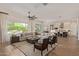 Bright, open living room with wood floors, a ceiling fan, and a kitchen in the background at 3400 S Whetstone Pl, Chandler, AZ 85286