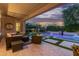 Covered patio with stylish outdoor furniture overlooking the beautiful pool and landscaped backyard at 3400 S Whetstone Pl, Chandler, AZ 85286