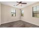 Bright bedroom features three windows, a ceiling fan, and wood-look flooring at 3900 E Baseline Rd # 137, Phoenix, AZ 85042