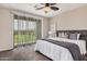 A cozy bedroom features a large bed, ceiling fan, and sliding glass doors to a balcony at 3900 E Baseline Rd # 137, Phoenix, AZ 85042