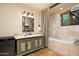 Well-lit bathroom with a marble countertop vanity, jetted tub, and travertine tile at 40039 N 107Th Pl, Scottsdale, AZ 85262