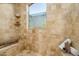 Luxurious bathroom with travertine tile, a frosted window, and a built-in bench at 40039 N 107Th Pl, Scottsdale, AZ 85262