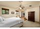Comfortable bedroom with neutral tones, ceiling fan, private balcony, and large wardrobe at 40039 N 107Th Pl, Scottsdale, AZ 85262