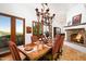 Formal dining room with a fireplace, wooden table, view of the outdoors, and beautiful chandelier lighting at 40039 N 107Th Pl, Scottsdale, AZ 85262