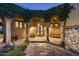 Charming front entrance featuring a decorative wrought-iron door, stone columns, and lush green vines at 40039 N 107Th Pl, Scottsdale, AZ 85262