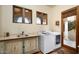 Convenient laundry room featuring modern washer and dryer, stylish sink, and outdoor access at 40039 N 107Th Pl, Scottsdale, AZ 85262