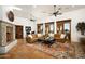 Spacious living room featuring tile floors, beamed ceilings, a fireplace, and multiple doors to the exterior at 40039 N 107Th Pl, Scottsdale, AZ 85262