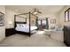 Main bedroom with a four-poster bed, seating area, and a private balcony with stunning mountain views at 40039 N 107Th Pl, Scottsdale, AZ 85262