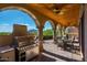 Outdoor kitchen features a built-in grill, dining area, and covered patio at 40039 N 107Th Pl, Scottsdale, AZ 85262