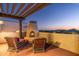 Relaxing outdoor patio features a fireplace, comfortable seating, and stunning sunset views at 40039 N 107Th Pl, Scottsdale, AZ 85262