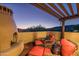 Cozy outdoor patio with a fireplace, comfortable seating, and views of the mountains at 40039 N 107Th Pl, Scottsdale, AZ 85262