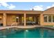 Inviting backyard patio with outdoor seating overlooking the sparkling pool and lush landscaping at 4281 S Tecoma Trl, Gold Canyon, AZ 85118