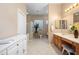 Bright bathroom featuring tiled floors, wooden cabinets, vanity, and a shower behind glass block partition at 4281 S Tecoma Trl, Gold Canyon, AZ 85118