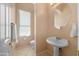 Well-lit powder room featuring pedestal sink, neutral tones, and privacy window at 4281 S Tecoma Trl, Gold Canyon, AZ 85118