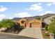 Charming home exterior with a three-car garage, low maintenance landscaping, and mountain views at 4281 S Tecoma Trl, Gold Canyon, AZ 85118