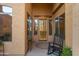 Inviting front porch with decorative plants, a rocking chair and sidelight windows at 4281 S Tecoma Trl, Gold Canyon, AZ 85118