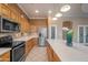Modern kitchen features stainless steel appliances, wooden cabinets and a breakfast bar with quartz countertops at 4281 S Tecoma Trl, Gold Canyon, AZ 85118
