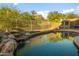 Beautiful pool area with rock waterfall feature, lush landscaping, and a charming gazebo for relaxation at 4281 S Tecoma Trl, Gold Canyon, AZ 85118