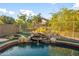 Inviting pool area with a rock waterfall feature surrounded by lush greenery at 4281 S Tecoma Trl, Gold Canyon, AZ 85118