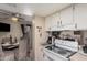 Well-lit kitchen featuring clean white cabinetry and modern appliances with open dining area at 4434 E Wood St, Phoenix, AZ 85040
