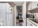 Kitchen with storage pantry, white appliances, and laminate countertop at 4434 E Wood St, Phoenix, AZ 85040