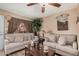Bright living room featuring plush sofas, a ceiling fan, and a wooden coffee table at 4434 E Wood St, Phoenix, AZ 85040