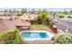 Backyard featuring a pool surrounded by greenery, a covered patio, and flowering bushes, perfect for outdoor enjoyment at 4510 W North Ln, Glendale, AZ 85302